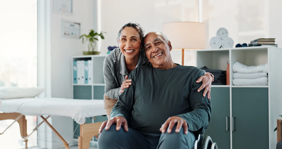 Smiling couple with a man seated in a wheelchair
