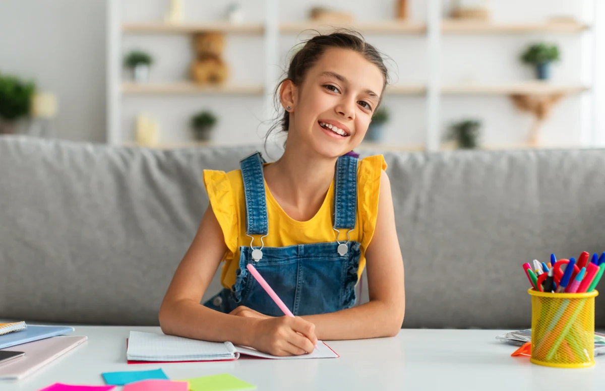 Smiling child writing in a notebook